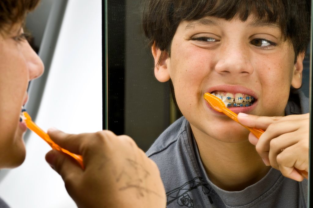 a pretten brushing their teeth with braces